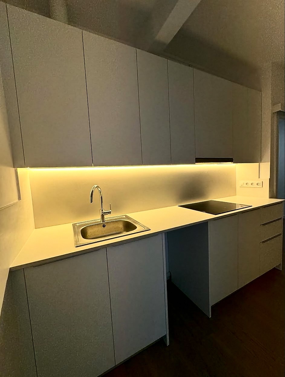 Cocina blanca con iluminación LED bajo los muebles altos, reforma de cocina VAGAM2000.